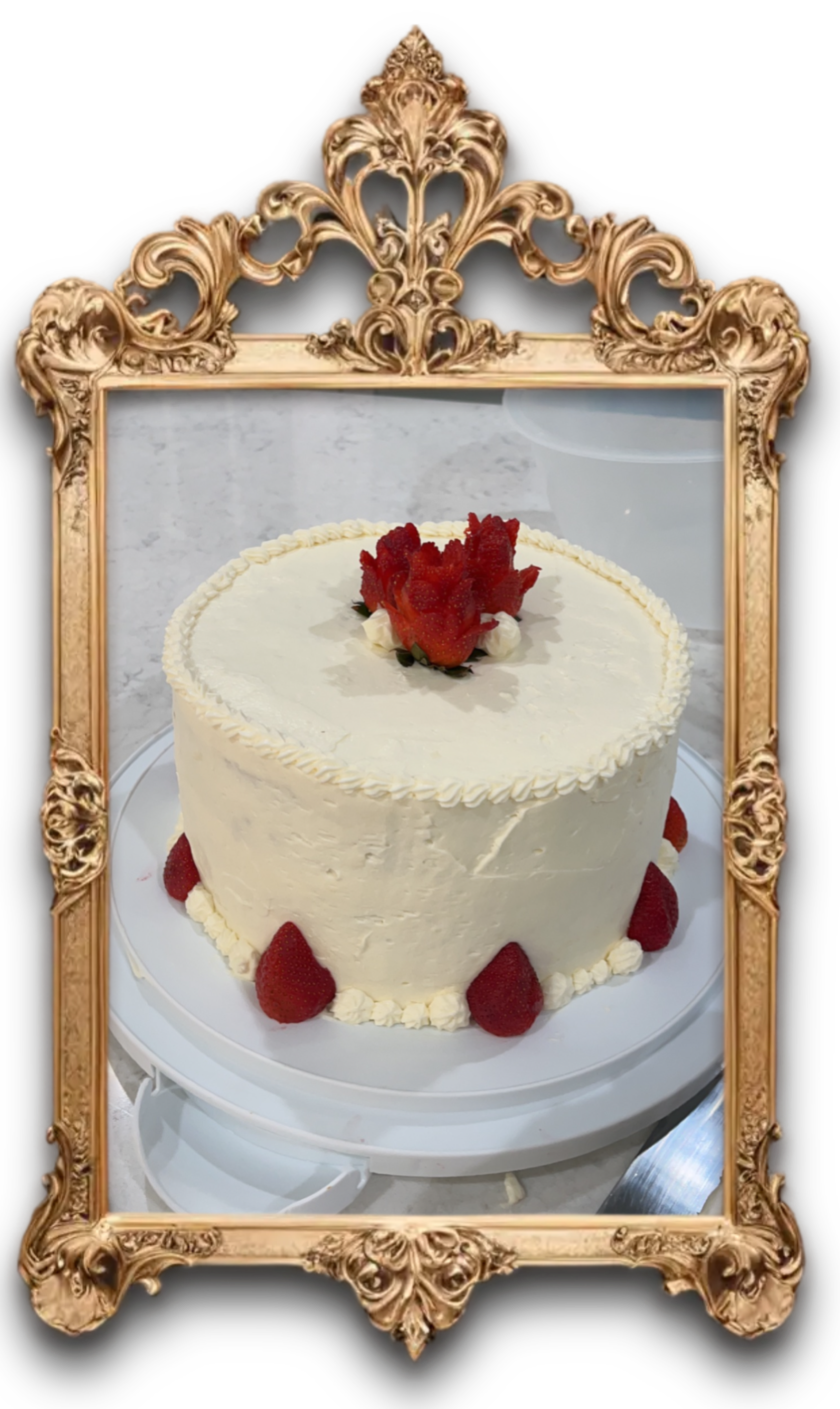 A white cake decorated with strawberries aligned to look like flowers.